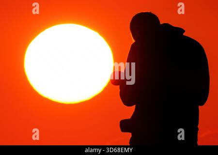 Isle Of Palms, Usa. November 2025. Ein Fotograf im Sonnenlicht fotografiert den Sonnenaufgang am Front Beach am 19. November 2025 in Isle of Palms, South Carolina. Quelle: Richard Ellis/Richard Ellis/Alamy Live News Stockfoto