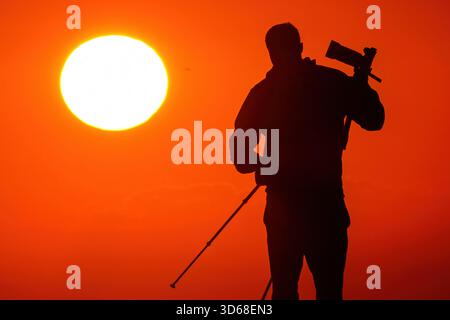 Isle Of Palms, Usa. November 2025. Ein Fotograf im Sonnenlicht fotografiert den Sonnenaufgang am Front Beach am 19. November 2025 in Isle of Palms, South Carolina. Quelle: Richard Ellis/Richard Ellis/Alamy Live News Stockfoto
