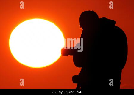 Isle Of Palms, Usa. November 2025. Ein Fotograf im Sonnenlicht fotografiert den Sonnenaufgang am Front Beach am 19. November 2025 in Isle of Palms, South Carolina. Quelle: Richard Ellis/Richard Ellis/Alamy Live News Stockfoto
