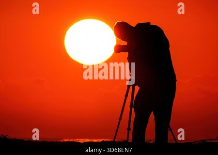 Isle Of Palms, Usa. November 2025. Ein Fotograf im Sonnenlicht fotografiert den Sonnenaufgang am Front Beach am 19. November 2025 in Isle of Palms, South Carolina. Quelle: Richard Ellis/Richard Ellis/Alamy Live News Stockfoto