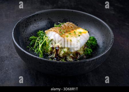 Frittiertes nordisches Fischfilet aus Dorsch mit Kartoffelpüree, grünem Gemüse und Balsamico-Essig-Relish-Umami-Sauce Stockfoto