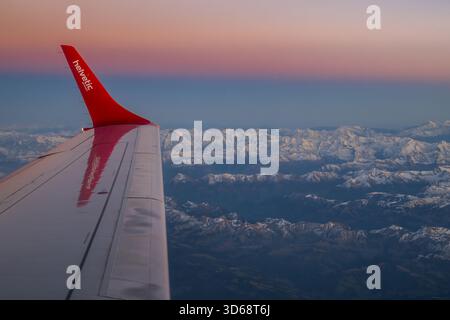 Luftaufnahme der Schweizer Alpen nach Sonnenuntergang von einem Helvetic Airways Embraer 190 Flugzeug Stockfoto