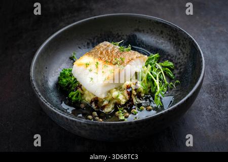 Frittiertes nordisches Fischfilet aus Dorsch mit Kartoffelpüree, grünem Gemüse und Balsamico-Essig-Relish-Umami-Sauce Stockfoto
