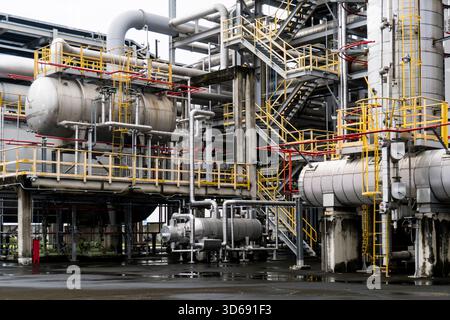 Eine industrielle Prozessanlage mit Wärmetauschern, Stahlplattformen und einem dichten Rohrleitungsnetz in einer detaillierten Ansicht. Stockfoto