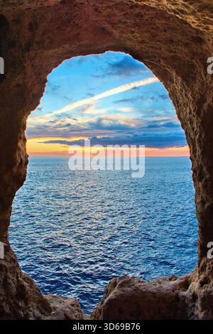 Wunderschöne Sommersonnenuntergangsszene an der Algarve, Portugal. Blick auf die Felsenhöhle Algar Seco. Stockfoto