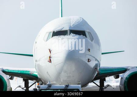 Schneebedecktes Cockpit eines Passagierflugzeugs vor der Enteisung. Wintertag am Flughafen. Stockfoto