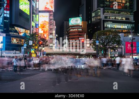 Nacht am Shibuya Crossing mit Neon-Reklametafeln und Bewegungsunschärfe Stockfoto