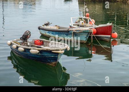 Drei kleine Holzfischboote liegen im Mevagissey Harbour, Cornwall, England Stockfoto