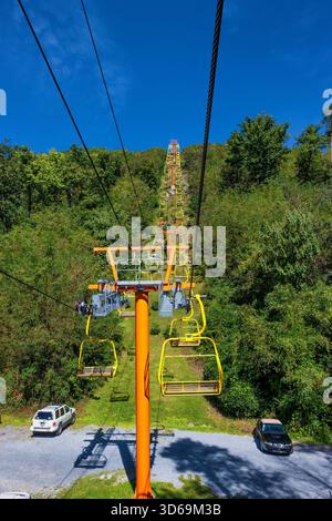 Gatlinburg, Tennessee, USA – 2. Oktober 2025: Autos, die unter dem Sessellift unter freiem Himmel geparkt werden, der die Menschen zum Skypark bringt. Stockfoto