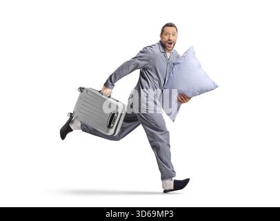 Aufnahme eines Mannes im Pyjama, der mit Koffer und Kissen auf weißem Hintergrund läuft Stockfoto