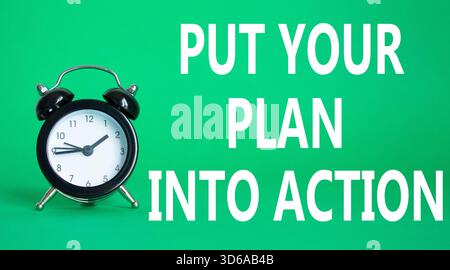Setzen Sie Ihren Plan in die Tat um. Konzeptworte setzen Ihren Plan auf weißes Puzzle in die Tat um. Schöner grüner Hintergrund mit Wecker. Business Conce Stockfoto