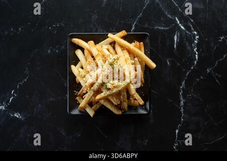 Eine Ansicht von oben nach unten auf einen Teller Knoblauch-Parmesan-Pommes. Stockfoto