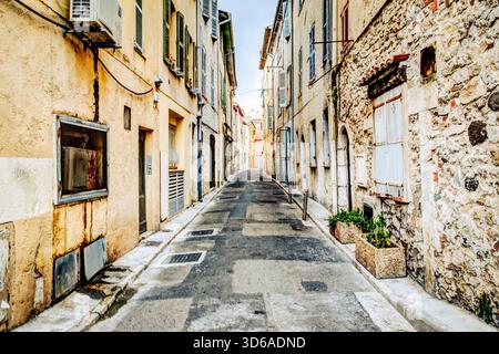 Eine ruhige, enge Straße mit Steinhäusern und Topfpflanzen in der Altstadt von Antibes, Frankreich. Stockfoto