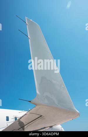 Nahaufnahme der Flügelspitze eines Business-Jets aus einem niedrigen Winkel, die die glatte aerodynamische Oberfläche, die Antennen und die reflektierende Oberfläche wieder zeigt Stockfoto