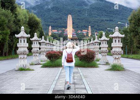 Junger Tourist mit Hut und Blick auf die drei Pagoden des Chongsheng Tempels, Dali, Yunnan, China Stockfoto