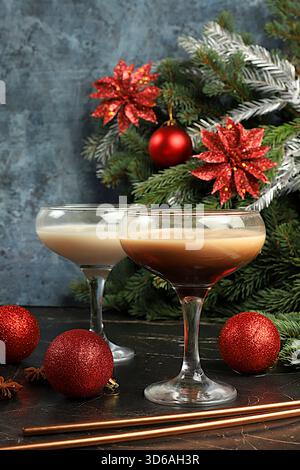 Weihnachtsmartini mit Zimt, Muskatnuss und dunkler Schokolade vor Tannenzweigen, Weihnachts- und Weihnachtskonzept. Ein warmes Milchgetränk du Stockfoto