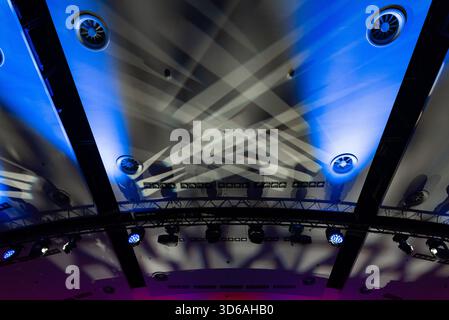 Auffällige geometrische Muster und leuchtende Farben sorgen für eine beeindruckende Optik an der Decke des Theaters. Die dramatische Beleuchtung wirft Schatten und betont den Architekten Stockfoto