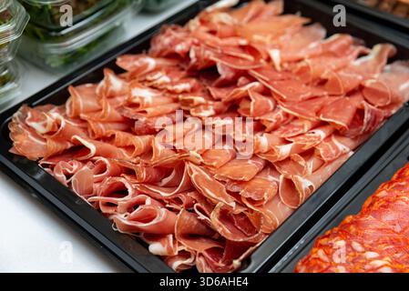 Ein Blick aus nächster Nähe auf eine wunderschön angelegte Platte mit geräuchertem Fleisch mit dünn geschnittenem Fleisch. Ideal für Feinschmecker-Präsentationen oder kulinarische Veranstaltungen. Stockfoto