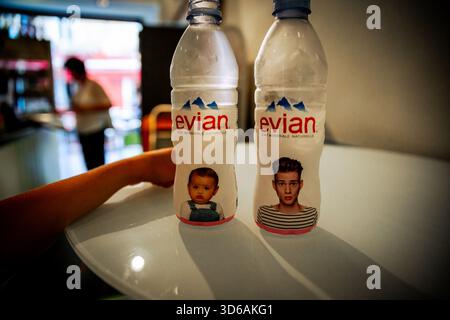 Evian Wasserflaschen mit illustrierten Gesichtern für Babys und Erwachsene auf einem Café in Nizza, Frankreich. Stockfoto