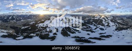 Sonnenuntergang, Alpenpanorama, traumhafte Winterlandschaft mit hoher Salve, blauer Himmel und Schnee, Berge und Bergtal, Luftblick Skiwelt Wilder Kais Stockfoto