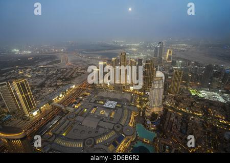 Ein atemberaubender nächtlicher Blick auf Abu Dhabi City von einem der höchsten Türme aus mit glitzernden Wolkenkratzern, beleuchteten Straßen und Reflexionen Stockfoto