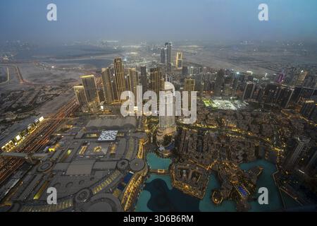Ein atemberaubender nächtlicher Blick auf Abu Dhabi City von einem der höchsten Türme aus mit glitzernden Wolkenkratzern, beleuchteten Straßen und Reflexionen Stockfoto