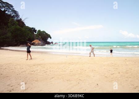 Touristen wandern entlang des tropischen Sandstrandes, Mahé Island, Seychellen Stockfoto