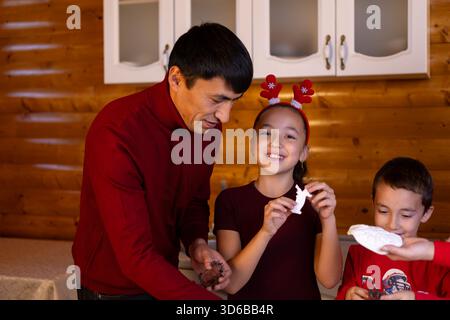 Mann und Kinder genießen Weihnachten Kuchen. Stockfoto