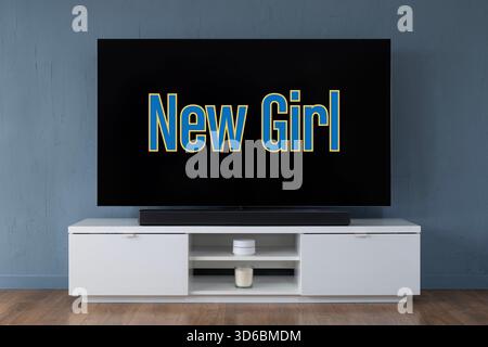 Ein Breitbild-OLED-Fernseher mit dem Logo der TV-Serie New Girl in einem modernen Wohnzimmer. Stockfoto