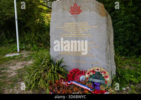 Kanadischer Gedenkstein mit Ahornblatt-Emblem und Erinnerungskränzen in der Nähe von Juno Beach in der Normandie, die an die kanadischen Streitkräfte des D-Day erinnern. Stockfoto