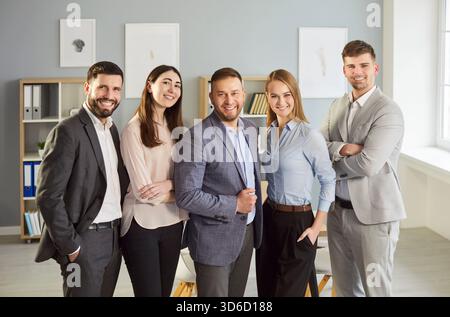 Gruppenporträt von lächelnden Geschäftsleuten, die gemeinsam in einem modernen Büro HR posieren Stockfoto
