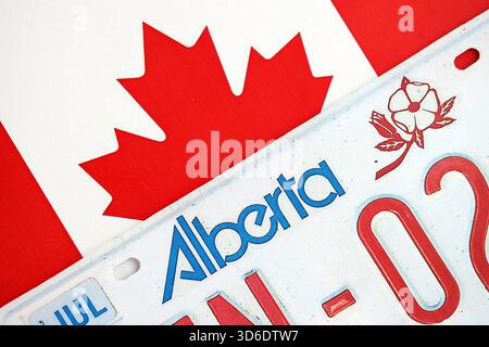 Alberta kanadisches Autokennzeichen auf der Flagge Kanadas Nahaufnahme. Führerschein- und Zulassungskonzept Stockfoto