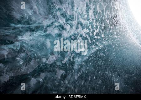 Blick auf das Innere einer Eishöhle, das Licht, das durch das durchscheinende blaue Eis filtert und komplizierte Muster auf die Wände wirft, Vatnajokull, Island Stockfoto