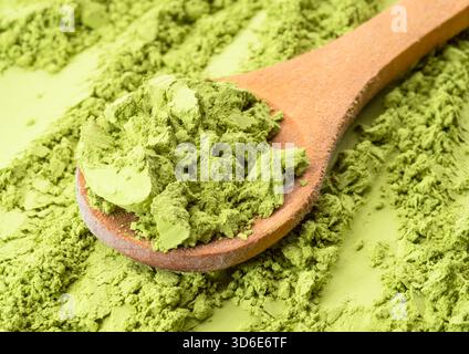 Hölzerner Löffel Matcha-Tee auf einem Haufen Matcha aus der Nähe. Stockfoto