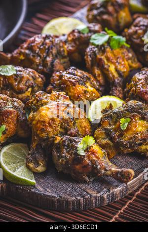 Scharfe Hähnchenflügel mit Kräutern und Limetten Stockfoto
