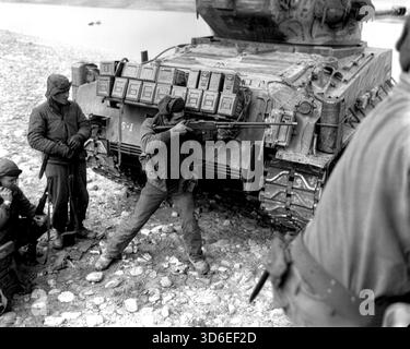 KOREA - 23. Februar 1951 - ein Soldat dieser Ranger-Patrouille der 5. RCT, 24. Infanterie-Division der US-Armee, nutzt sein BAR-Gewehr, um das Feuer gegen die schweren chinesischen kommunistischen Kleinwaffen und Mörserfeuer zurückzuwerfen, die sie am Ufer des Han-Flusses festgehalten haben. Auf der linken Seite meldet ein anderer Soldat die Siuation per Feldradio an das Hauptquartier – Foto: Geopix/US Army/Chang Stockfoto