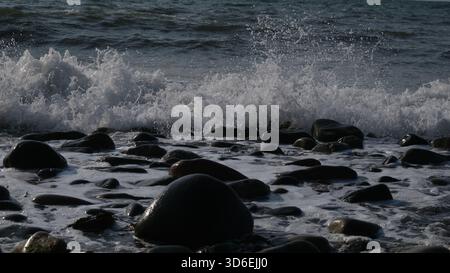 Irische Meereswellen brechen am Trefor-Strand in Nordwales, großbritannien Stockfoto