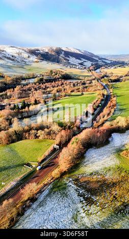 Ein Luftbild mit vertikaler Drohne, das die Straße A9 in einer hellen Winterlandschaft in der Nähe von Pitlochry in den schottischen Highlands zeigt. Das Bild erfasst Straßen, Felder, Hügel und Schneeflächen unter klarem Morgenlicht. Stockfoto