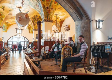 München, 15. Oktober 2024: Musiker spielen traditionelle bayerische Musik in einem Biersaal und unterhalten die Gäste. Stockfoto