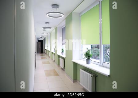 Blick auf den stilvollen Flur mit Fenstern in der Schule Stockfoto
