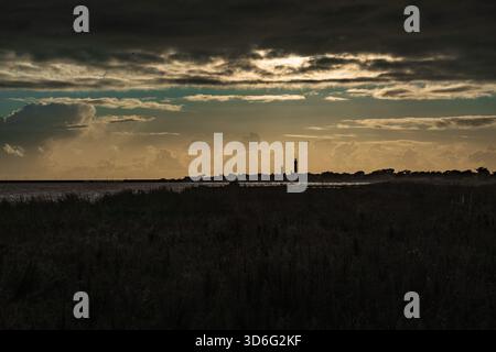 Sonnenuntergang über dem Meer mit Leuchtturm Eckmühl im Hintergrund, Pays Bigouden Finistère Bretagne France Stockfoto