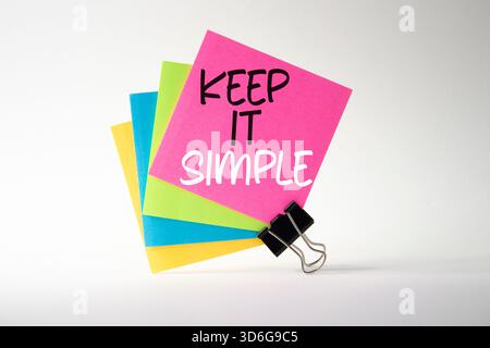 Lassen Sie es einfach. Konzeptwörter halten es auf Haftnotizen einfach. Schöner weißer Hintergrund. Business und IT-Konzept einfach halten. Kopierbereich. Stockfoto