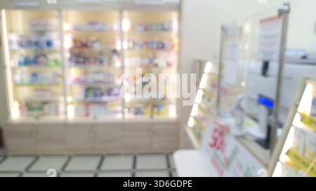 Verschwommenes Innere einer gut beleuchteten Apotheke mit Regalen voller Medikamente und Produkte Stockfoto