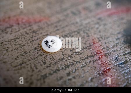 Nahaufnahme einer kleinen runden weißen Pille auf einer strukturierten Oberfläche. Stockfoto