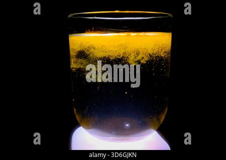 Makro Des Goldenen Kurkuma-Pulvers, Das Sich In Glas Wasser Löst Stockfoto