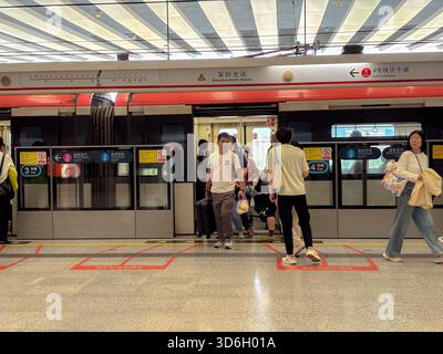 Shenzhen North Station U-Bahn-Plattform während des Einstiegs. Passagiere steigen in einen Zug der Linie 4 im geschäftigen Verkehrsknotenpunkt Shenzhen, China, ein Stockfoto