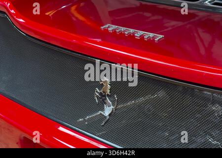 Close-up cutout detail part of red rear rear end of sports car Supercar Ferrari with logo trademark of luxury car manufacturer Jumping horse Cavallino Stockfoto