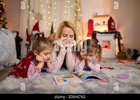 Mutter liest ihren Töchtern eine weihnachtsgeschichte vor Stockfoto