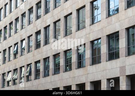 Fassade eines modernen Bürogebäudes mit großen reflektierenden Fenstern, die städtische Architektur und klare Designlinien zeigen Stockfoto