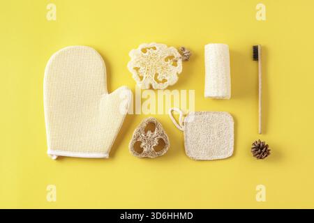 Set aus umweltfreundlichen Badezimmerzubehör, Badewerkzeugen, natürlicher Bambuszahnbürste, Schwamm. Kosmetikprodukte ohne Abfall auf Gelb. Kunststofffrei. Su Stockfoto